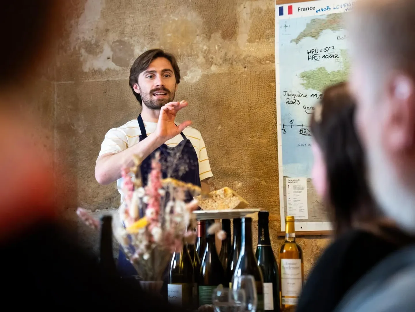 Maxime Malbranque, fromager, explique un accord devant une carte des régions de France